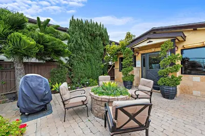 a patio with chairs and a table and a house at Villa Palazzo D'Stella at the Retreat in Laguna Beach