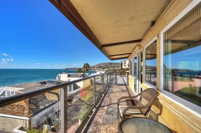 a balcony with chairs and a view of the ocean at Villa Roma at the Retreat in Laguna Beach in Laguna Beach