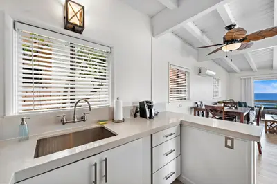 a white kitchen with a sink and a dining room at Sleepy Hollow Villas #2 in Laguna Beach in Laguna Beach
