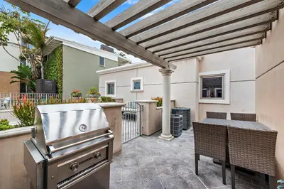 a outdoor patio with a grill and a table and chairs at Villa Lanai at the Sunset Cove Villas in Laguna Beach