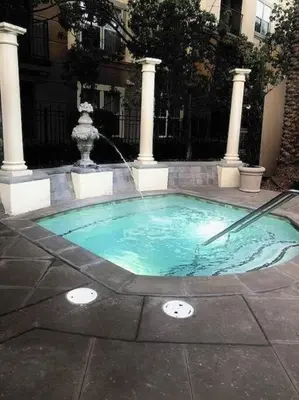 a swimming pool with a fountain in a courtyard at Luxury condo near Irvine Business & UCI Hospital in Irvine