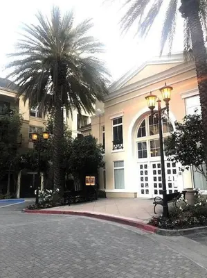 a building with palm trees in front of a street at Luxury condo near Irvine Business & UCI Hospital in Irvine