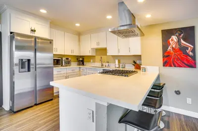 a kitchen with white cabinets and a refrigerator at Newport Beach Vacation Rental Steps to Shore! in Newport Beach
