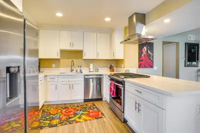 a kitchen with white cabinets and a rug on the floor at Newport Beach Vacation Rental Steps to Shore! in Newport Beach