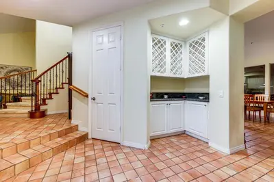 a kitchen with white cabinets and a staircase at 1 Mi to the Beach! Ocean-View Encinitas Home in Encinitas