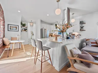 a kitchen and living room with a counter and chairs at Luxe OB Home, Walk to Beach, Sauna, and Backyard in San Diego