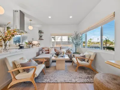 a living room with a lot of furniture and windows at Luxe OB Home, Walk to Beach, Sauna, and Backyard in San Diego
