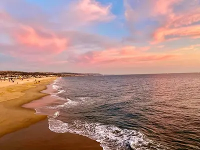a beach with people walking on the sand and the water at Escape to Luxury Newport Coast Pelican Gated Home in Newport Beach