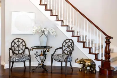 a hallway with two chairs and a table and stairs at Escape to Luxury Newport Coast Pelican Gated Home in Newport Beach
