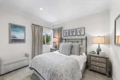 a bedroom with a bed and a chair and a window at Laguna Villa in Laguna Beach