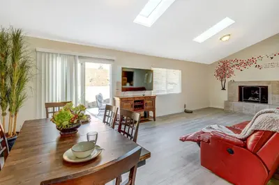 a living room with a table and a red chair at Sunny Vista Vacation Rental Home 12 Mi to Beach! in Vista