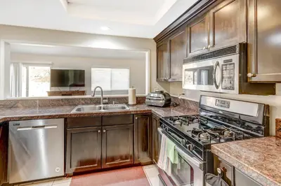a kitchen with stainless steel appliances and wooden cabinets at Sunny Vista Vacation Rental Home 12 Mi to Beach! in Vista