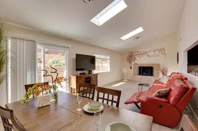 a living room with a red couch and a table at Sunny Vista Vacation Rental Home 12 Mi to Beach! in Vista