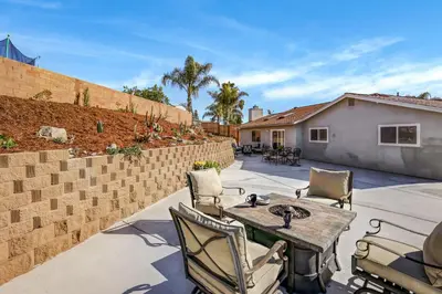 a patio with a table and chairs and a brick wall at Sunny Vista Vacation Rental Home 12 Mi to Beach! in Vista