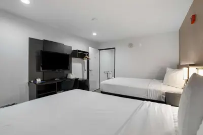 a hotel room with two beds and a flat screen tv at Suites Escondido CA in Escondido