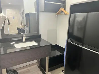 a bathroom with a sink and a mirror at Suites Escondido CA in Escondido