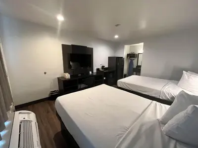a hotel room with two beds and a flat screen tv at Suites Escondido CA in Escondido