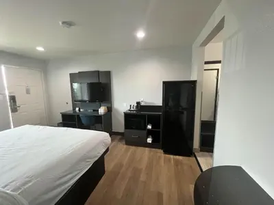 a bedroom with a bed and a dresser and a mirror at Suites Escondido CA in Escondido