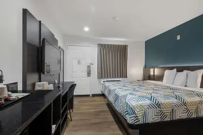 a hotel room with a bed and a bathroom at Suites Escondido CA in Escondido