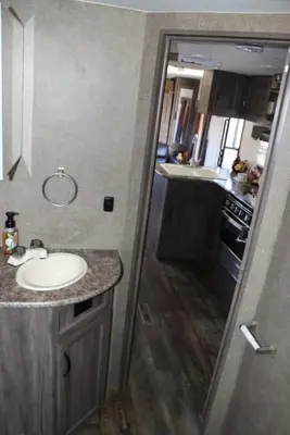 a small bathroom with a sink and a kitchen at RV quiet place in the mountain in Hemet