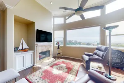 a living room with a ceiling fan and a fireplace at Lagoon Sunrise 205 - 30-Night Minimum in Carlsbad