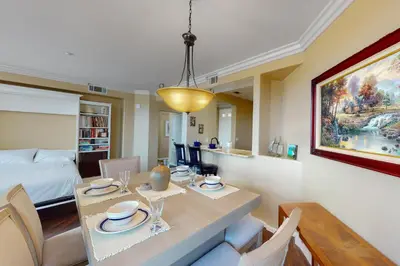 a dining room with a table and a bedroom at Lagoon Sunrise 205 - 30-Night Minimum in Carlsbad