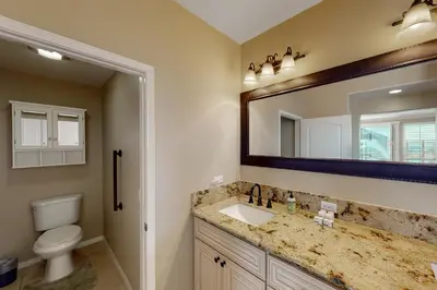 a bathroom with a sink and a toilet and a mirror at Lagoon Sunrise 205 - 30-Night Minimum in Carlsbad