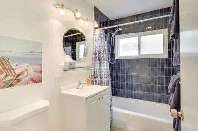 a bathroom with a sink and a tub and a window at San Diego Home with Deck Walk to Mission Beach! in San Diego