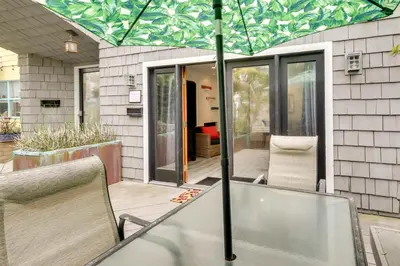 a patio with a table and chairs under an umbrella at San Diego Home with Deck Walk to Mission Beach! in San Diego