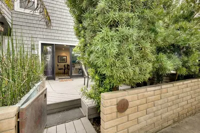 a house with a retaining wall next to a yard at San Diego Home with Deck Walk to Mission Beach! in San Diego