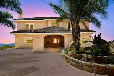 a house with a palm tree and a driveway at Mountaintop Ramona Home Private Pool, Near Lake! in Ramona