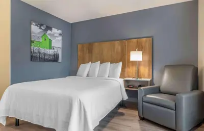 a bedroom with a large bed and a chair at Extended Stay America Premier Suites - San Diego - San Marcos in San Marcos